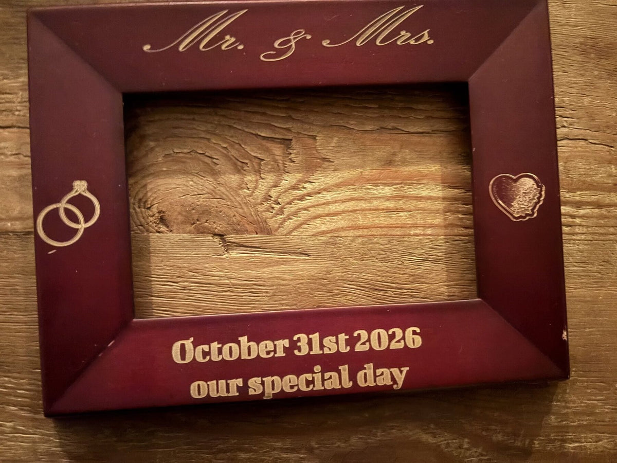 Custom engraved wood photo frame angled view showing rings and heart icons